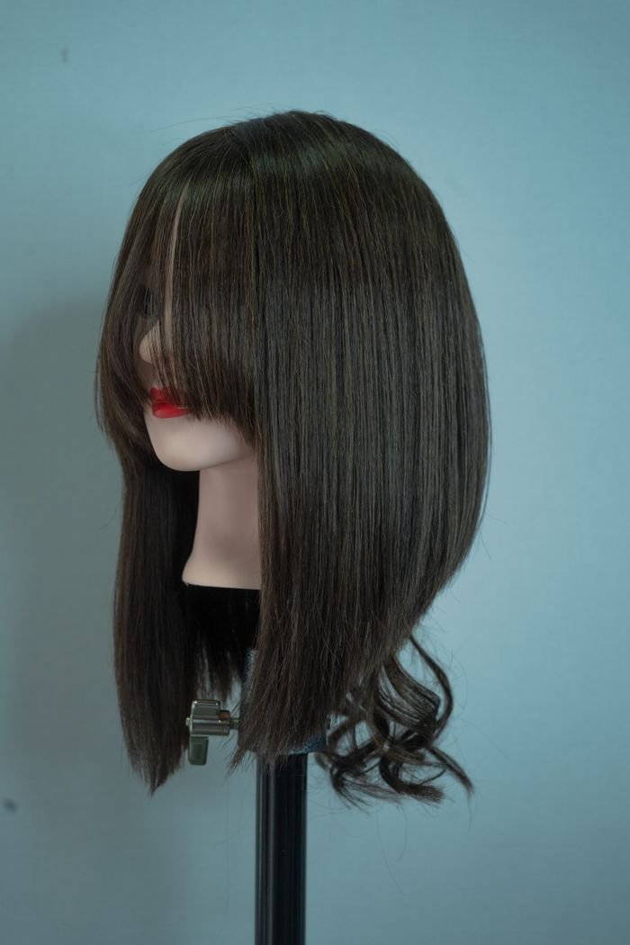 Mannequin with straight, long brown hair against a gray background, showcasing hair styling.